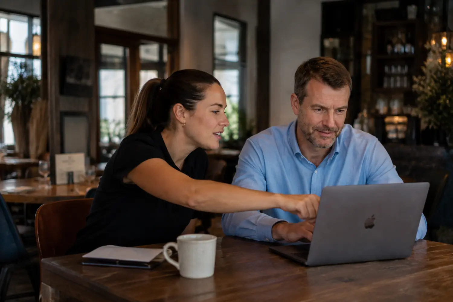 An OnTheMonee specialist helping a venue operator set up tipping on a laptop